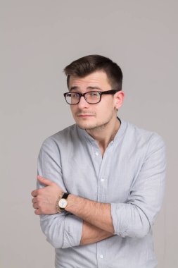 Modern genç adam gri bir arka plan üzerinde izole bir gömlek