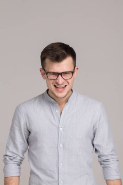 Modern genç adam gri bir arka plan üzerinde izole bir gömlek