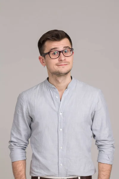 Μοντέρνα νεαρός άνδρας σε ένα πουκάμισο που απομονώνονται σε ένα γκρίζο φόντο — Φωτογραφία Αρχείου