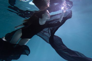 Genç Slender Kız bir bezle suyun altında. Su Büyüsü. Su altı fotoğrafçılığı. Sanat