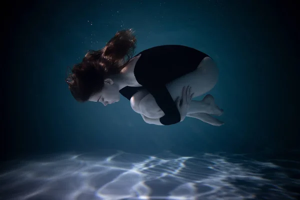 Маленькая стройная девочка под водой с тряпкой. Магия воды. Подводная фотография. Искусство — стоковое фото