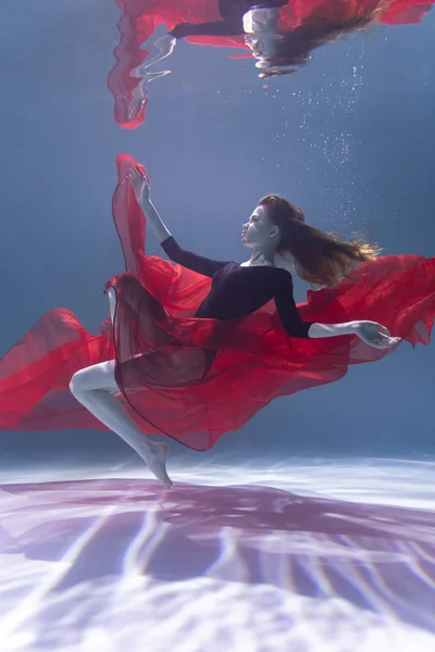 Jeune fille mince sous l'eau avec un chiffon. Magie de l'eau. Photographie sous-marine. L'art — Photo