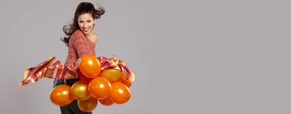 Junge hübsche Frau mit bunten Luftballons — Stockfoto