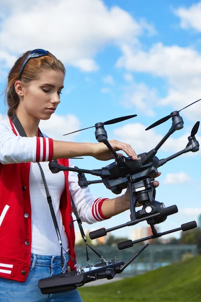 A woman is standing and holding drone — Stock Photo, Image