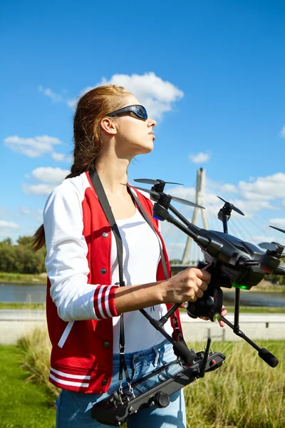 Uma mulher está de pé e segurando drone — Fotografia de Stock