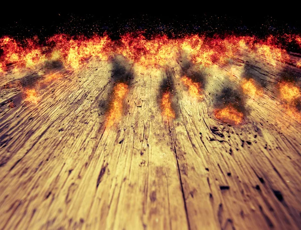 Eldslågor på ett bord av trä bakgrund — Stockfoto