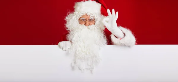 Weihnachtsmann zeigt in leeres Werbebanner isoliert auf r — Stockfoto