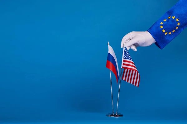 Två flaggor och hand på en blå bakgrund — Stockfoto