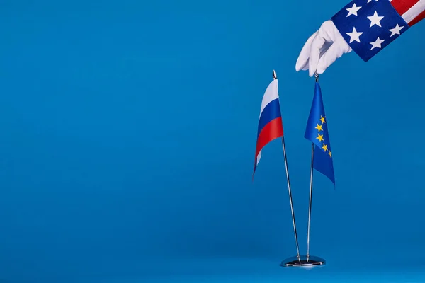 Zwei Flaggen und Hand auf blauem Hintergrund — Stockfoto