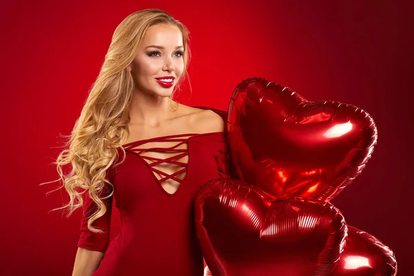 Mooie blonde vrouw poseren met hart ballonnen — Stockfoto