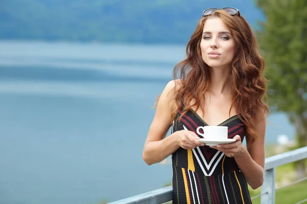 Portret van een jonge vrouw die haar's ochtends koffie drinken — Stockfoto