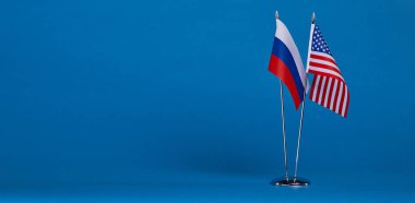 Mavi bir arka plan üzerinde iki bayrak