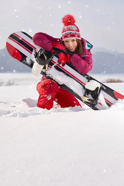 Mulher snowboarder posando na neve — Fotografia de Stock