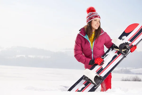 Femme snowboarder posant sur la neige — Photo