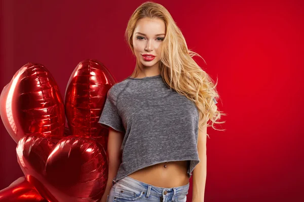 Жінка з червоними кульками серця — стокове фото