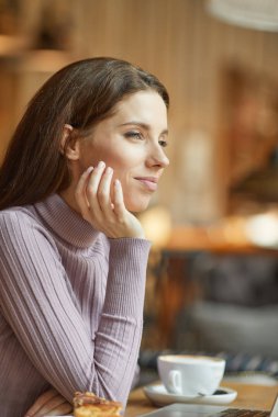 Güzel esmer kafede dizüstü bilgisayar kullanarak