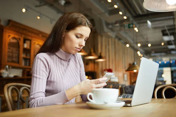 Beautiful brunette using laptop in cafe — Stock Photo, Image