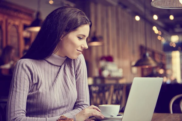 Жінка працює з ноутбуком в кафе — стокове фото