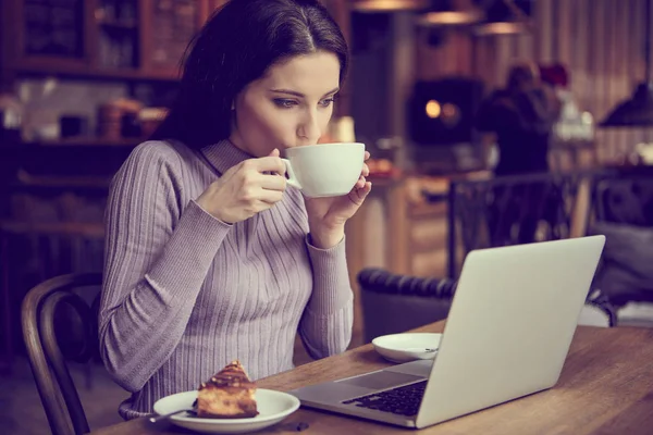 Žena pracující s přenosným počítačem v kavárně — Stock fotografie