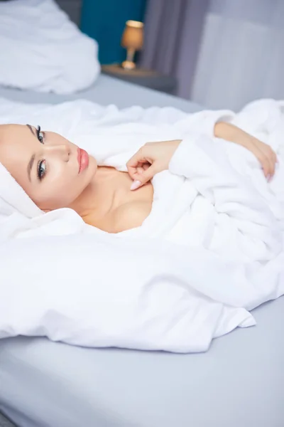 En kvinna i badrock och handduk på huvudet — Stockfoto