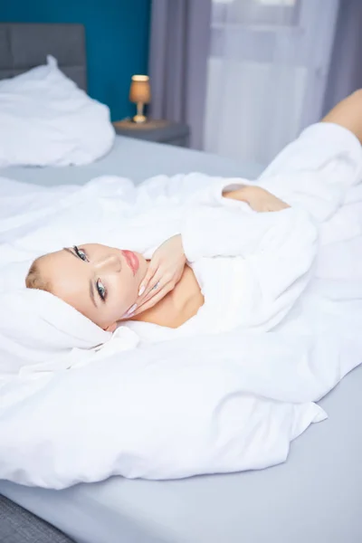 A woman in a bathrobe and a towel on her head — Stock Photo, Image