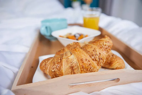 Frühstück im Bett mit Kaffee und Croissants — Stockfoto