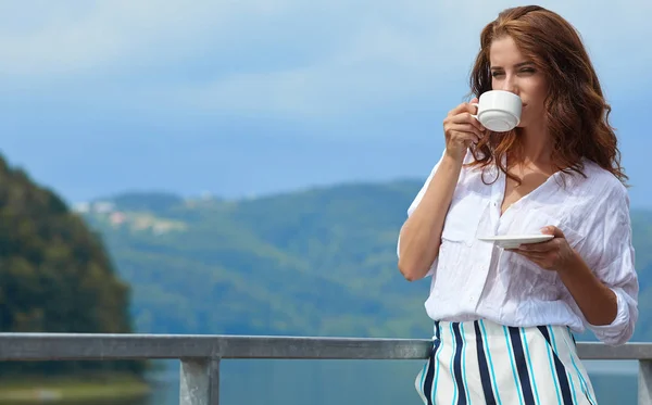 Mooie vrouw ontspannen op het terras van het huis — Stockfoto