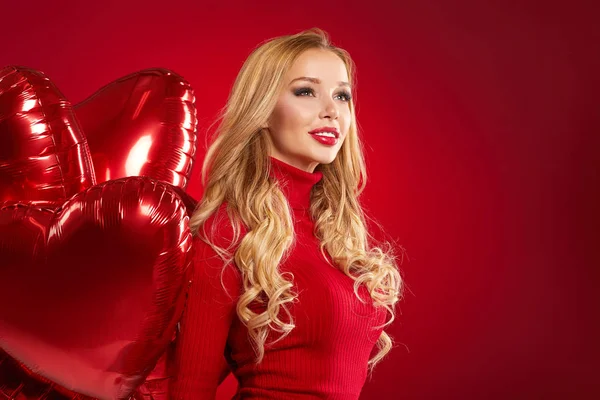 Mooie blonde vrouw die zich voordeed op rood — Stockfoto