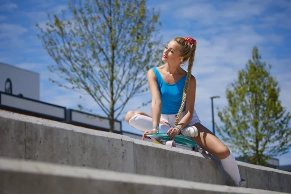 Красивая и сексуальная девушка сидит на скейтборде — стоковое фото