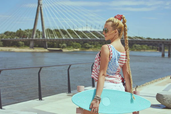 Mooie jonge blonde vrouw met zijn longboard in de stad van s — Stockfoto