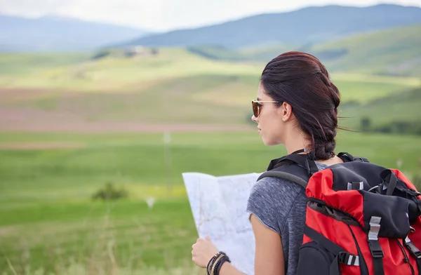 Girl holding map with backpack — Stock Photo, Image