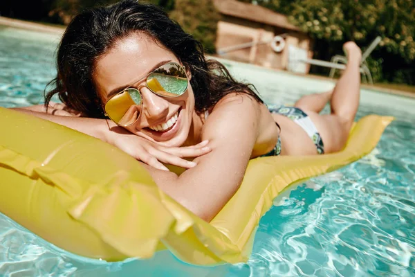 Woman in bikini sunbathing on air mattress — Stock Photo, Image