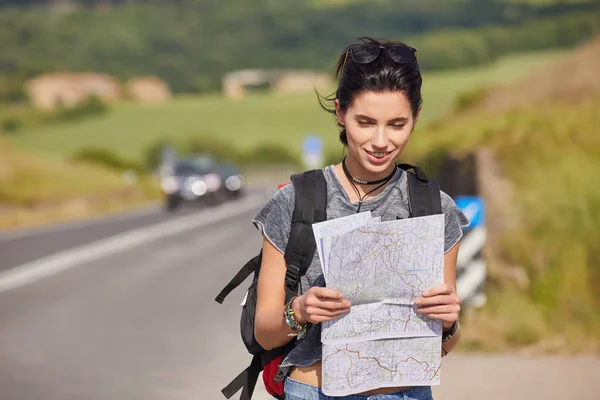 Girl holding map with backpack — Stock Photo, Image