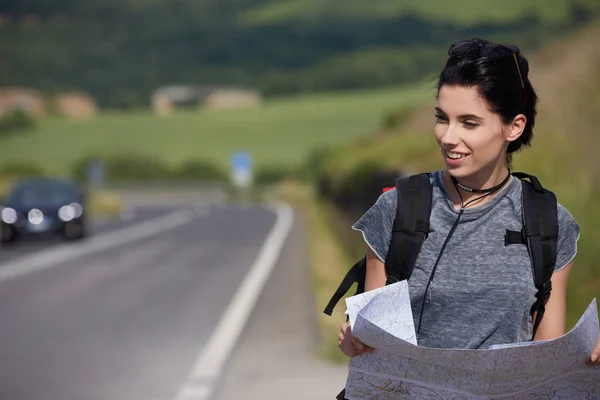 Girl holding map with backpack — Stock Photo, Image