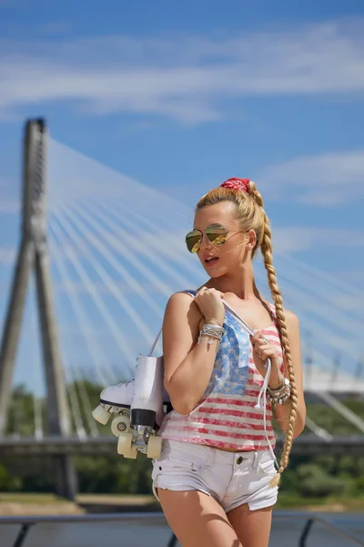 Beautiful young blond woman with braid over city bridge — Stock Photo, Image