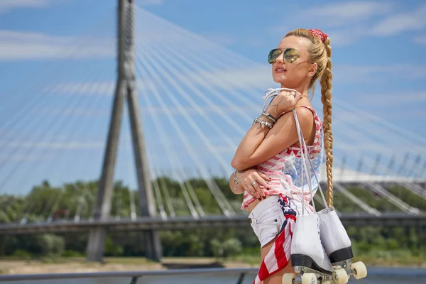 Mooie jonge blonde vrouw met vlecht over stad brug — Stockfoto