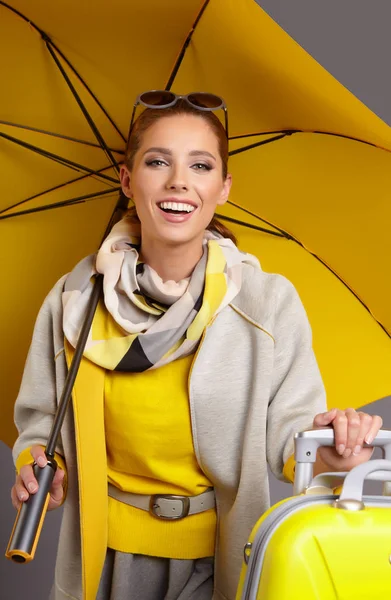 Glamour vrouw met gele koffer — Stockfoto