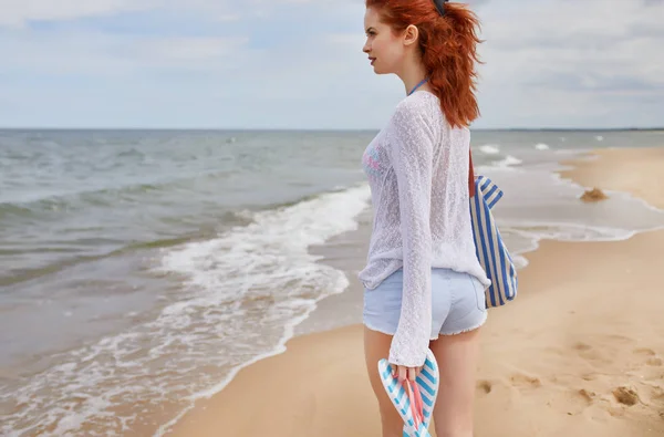 Red-head flicka på stranden i soluppgång. — Stock fotografie