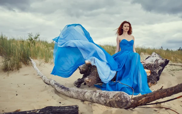 Sommerfrau im blauen Kleid am Strand — Stockfoto