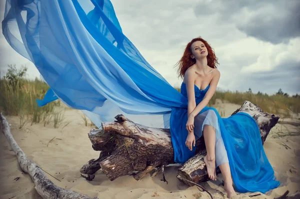 Mulher de verão em um vestido azul na praia — Fotografia de Stock