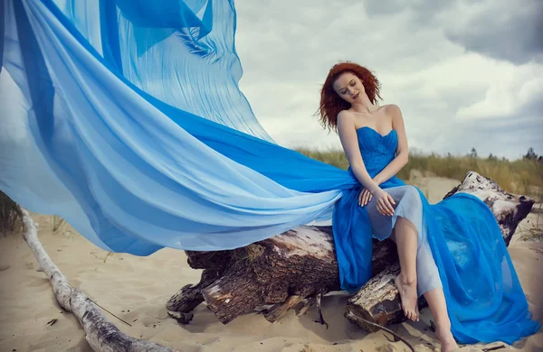 Zomer vrouw in een blauwe jurk op het strand — Stockfoto