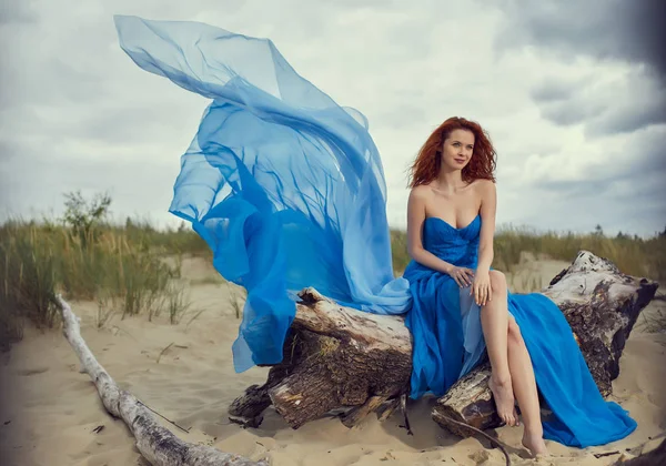 Zomer vrouw in een blauwe jurk op het strand — Stockfoto