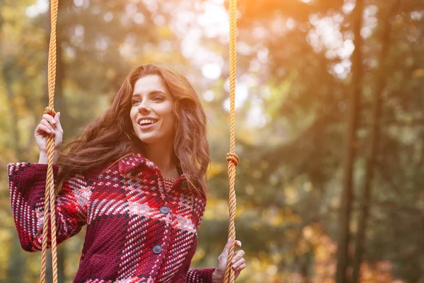 Donna su un'altalena in un parco autunnale — Foto Stock