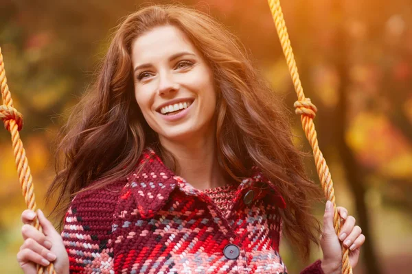 Woman on a swing in an autumn park — Stock Photo, Image