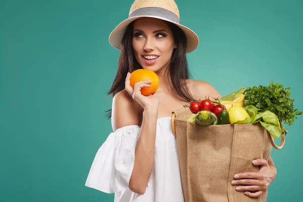 Mujer sosteniendo bolsa de compras y naranja —  Fotos de Stock