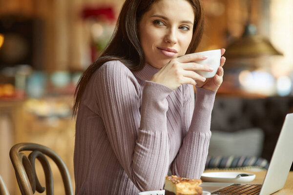 woman drinking coffee in cafe 