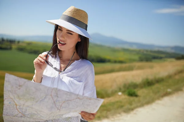 Mulher de chapéu segurando mapa de papel — Fotografia de Stock