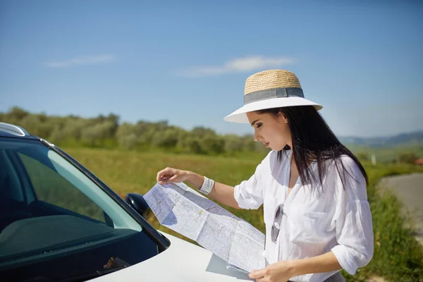 Woman with map at car checking route — Stock Photo, Image