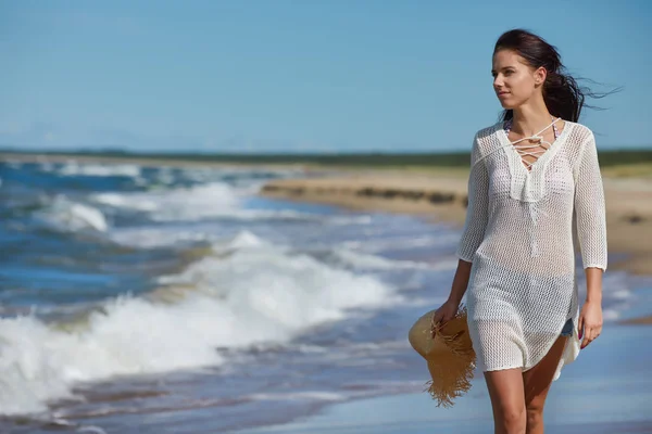 Mladá žena chůze na krásné pláži — Stock fotografie