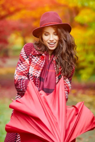 Woman folding umbrella in autumn park — Stock Photo, Image